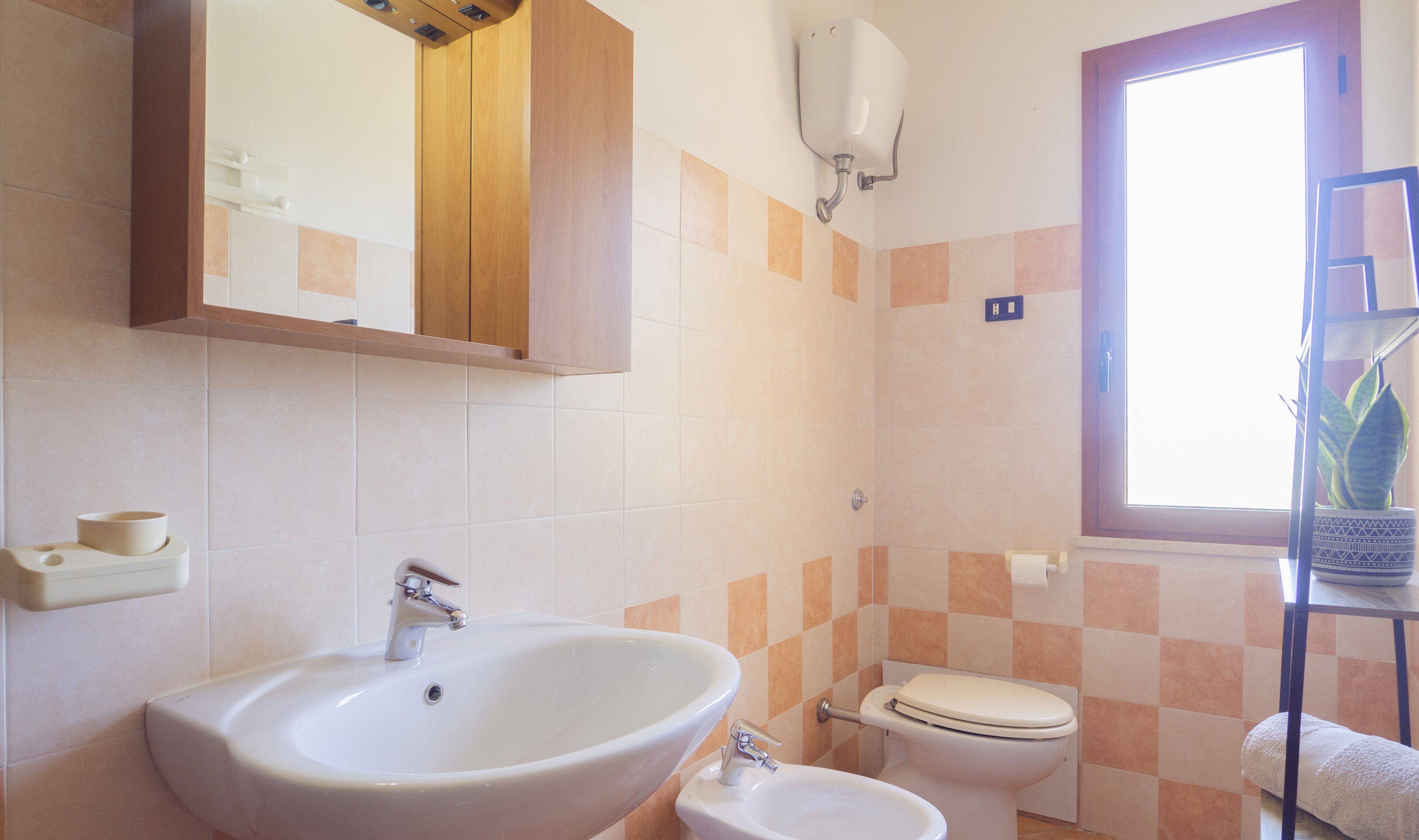 A bathroom with a sink, toilet, and a mirror above the sink.
