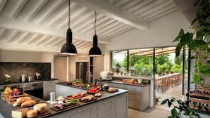 A modern kitchen with a large island, white cabinetry, and pendant lighting. - Il Casolese Vignamaggio Private Pool  (Greve in Chianti)