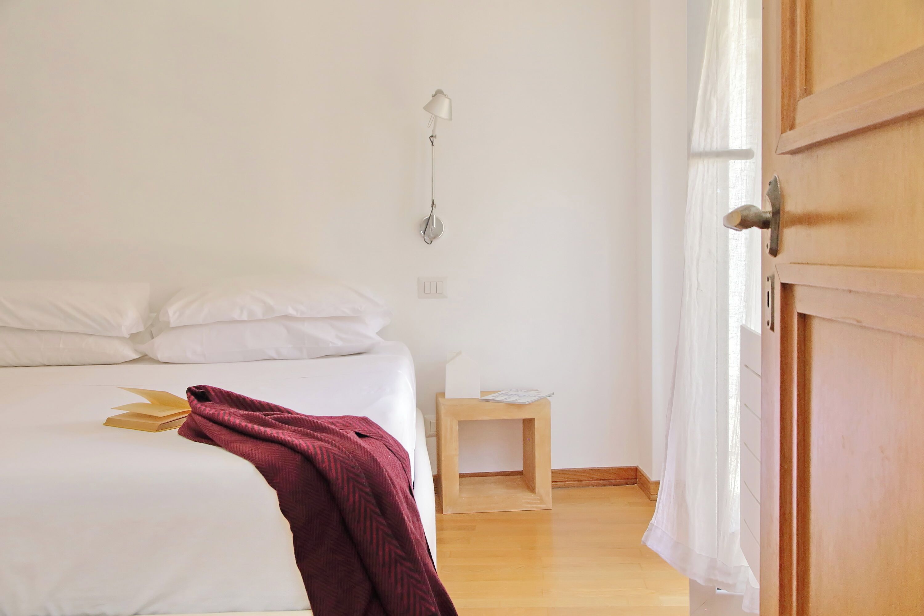 Une chambre à coucher avec un lit, une table de chevet, une lampe et une porte en bois.