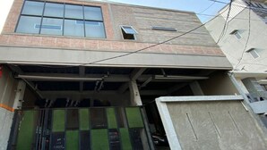 Een gebouw met een garage-ingang, een metalen poort en een bakstenen gevel.