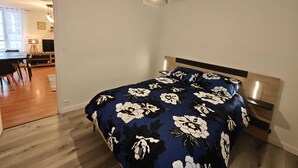 Un dormitorio con cama, escritorio y silla.