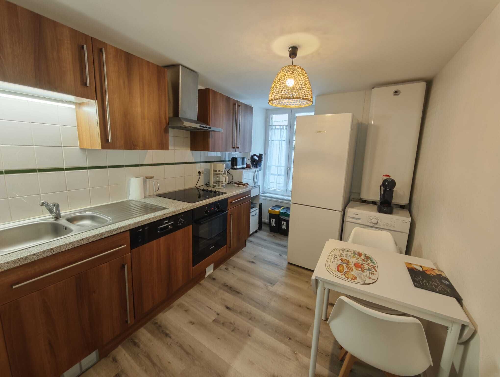 A modern kitchen with wooden cabinets, a dishwasher, a stove, and a refrigerator.