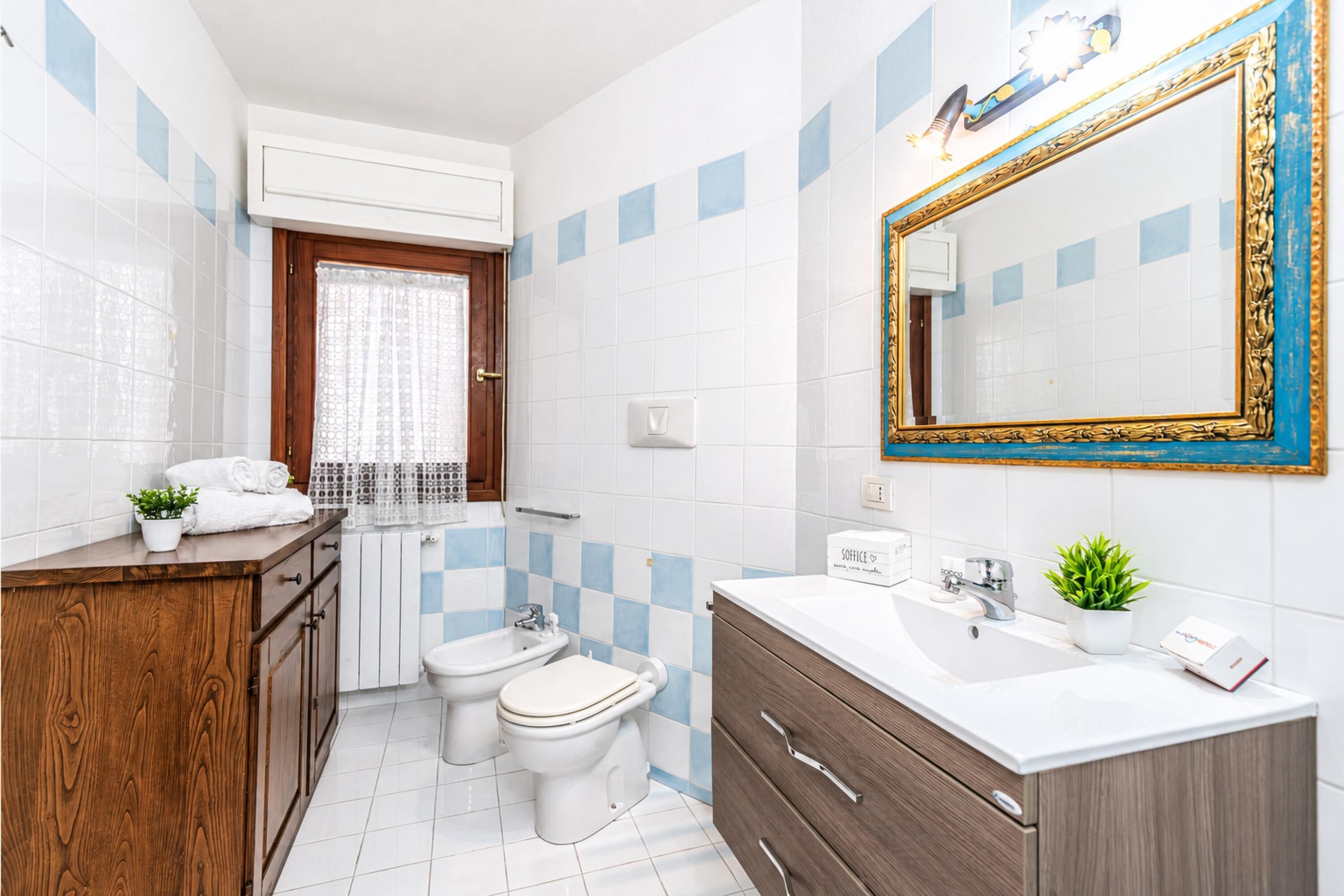 Un baño moderno con tocador de madera, un espejo grande y un lavabo blanco.