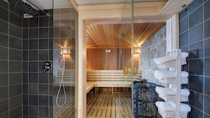 A sauna with a wooden bench, a glass door, and a stone wall with towels. - Dom Nad Wodospadem pod Snieznymi Kotlami (Jelenia Góra)