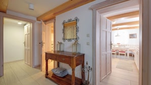 A hallway with a wooden table, a mirror, and a coat rack. There are doors leading to other rooms. - Dom Nad Wodospadem pod Snieznymi Kotlami (Jelenia Góra)