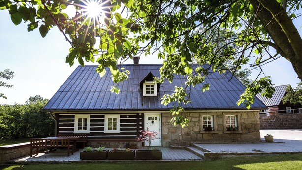 A log cabin with a stone foundation, a wooden deck, and a small porch with a bench. - Dom Nad Wodospadem pod Snieznymi Kotlami (Jelenia Góra)