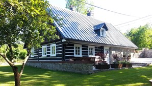 A log cabin with a stone foundation, a metal roof, and a porch with a bench. - Dom Nad Wodospadem pod Snieznymi Kotlami (Jelenia Góra)