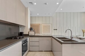 A modern kitchen with a gas stove, a coffee maker, and a sink.