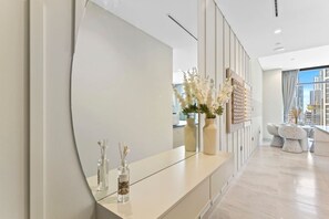 Een moderne hotel lobby met een gebogen receptiebalie, decoratieve vazen en een stadszicht door grote ramen.