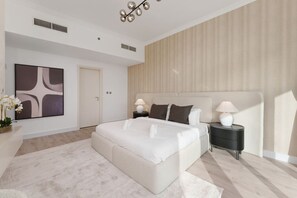 A modern bedroom with a large bed, two bedside tables, a wall-mounted lamp, and a large abstract painting. - Exquisite 2-Bedroom with Panoramic Marina view (Dubai)