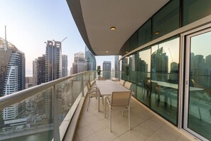 A balcony with a table and chairs, offering a city view.