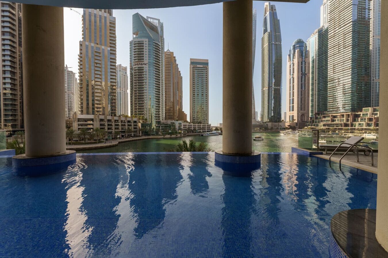Piscina com vista para edifícios altos e um corpo d'água.
