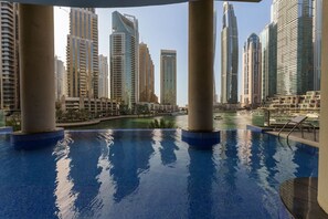 A swimming pool with a view of high-rise buildings and a body of water.