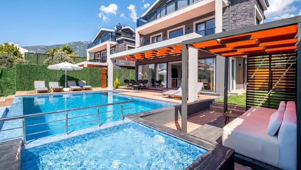Una casa moderna con piscina, mobiliario de exterior y un patio cubierto.