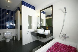 Deluxe kamer | Badkamer | Een aparte badkuip en douche, een haardroger, pantoffels, handdoeken