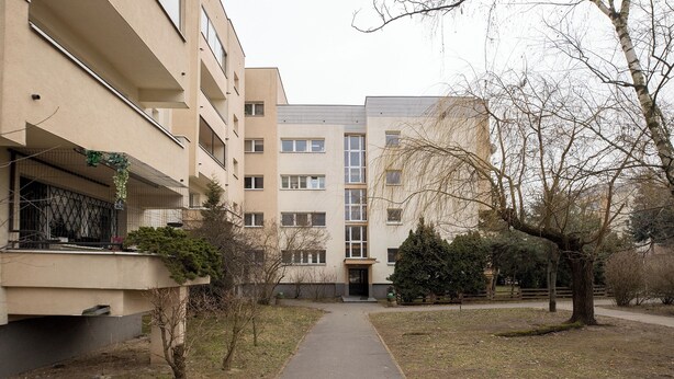 A pathway leading to a building with multiple windows and balconies. - ShortStayPoland Piekałkiewicza B112 (Warsaw)