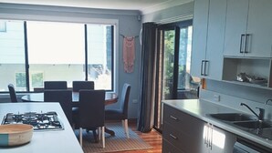 Una cocina moderna con estufa a gas, piso de madera y ventanas amplias con vistas.
