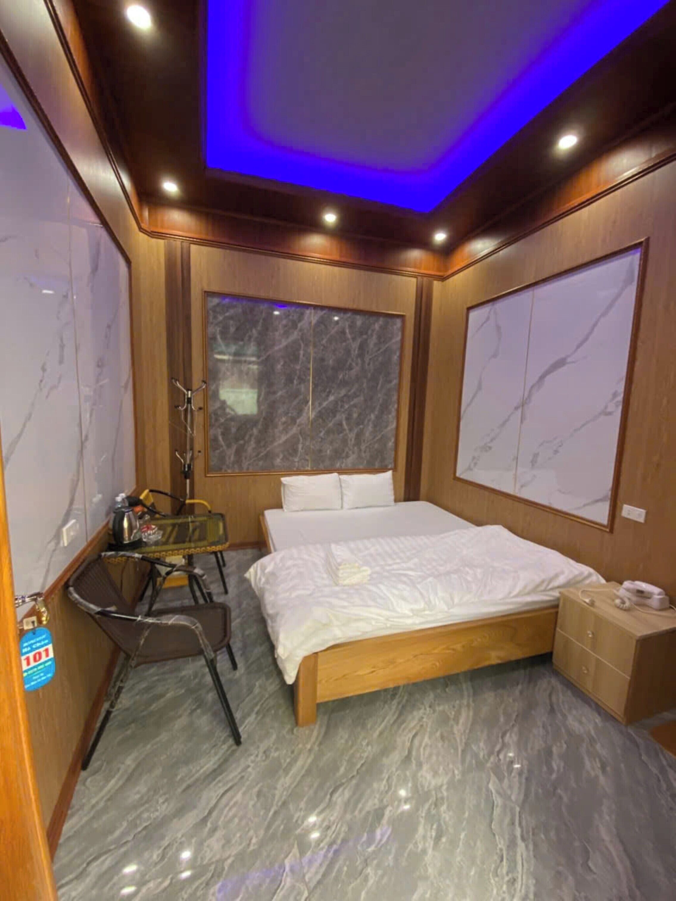 Een slaapkamer met een houten bed, een bureau en een stoel.