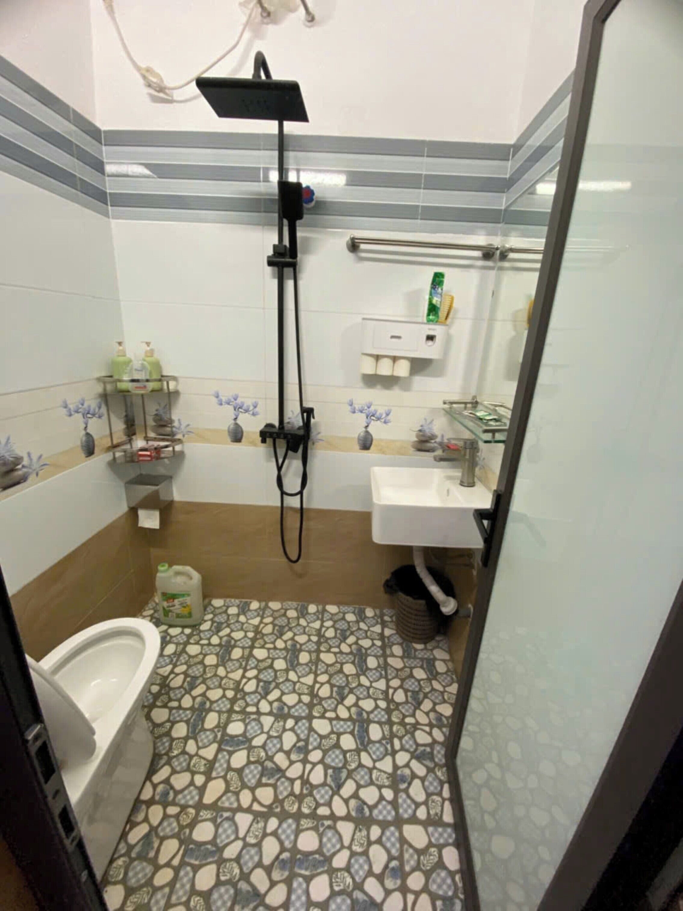 Et badeværelse med brusebad, toilet og håndvask.