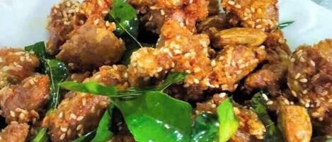 Un plato con semillas de sésamo y hojas verdes, posiblemente un salteado o ensalada.