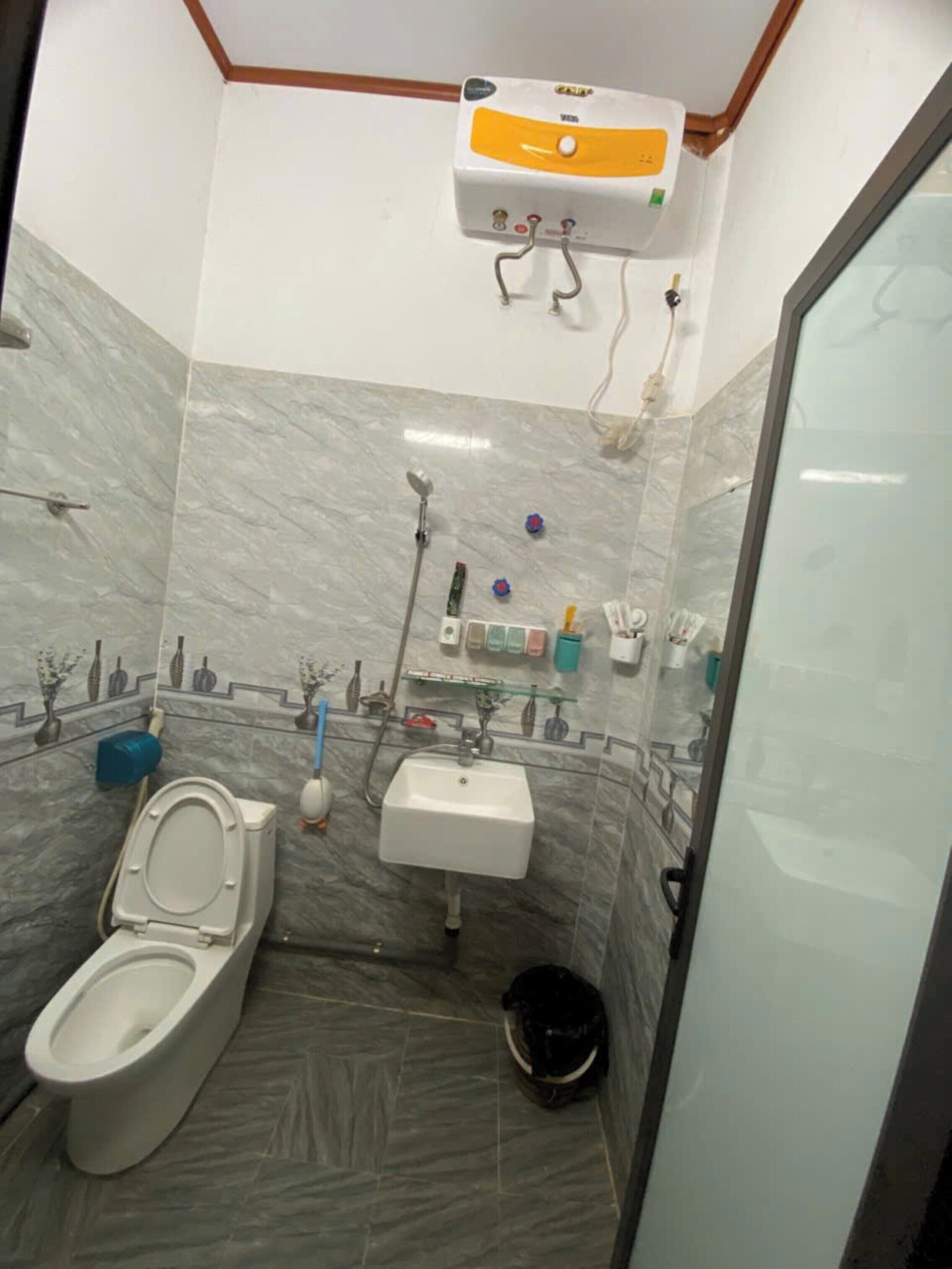 Een badkamer met toilet, wastafel en douche.