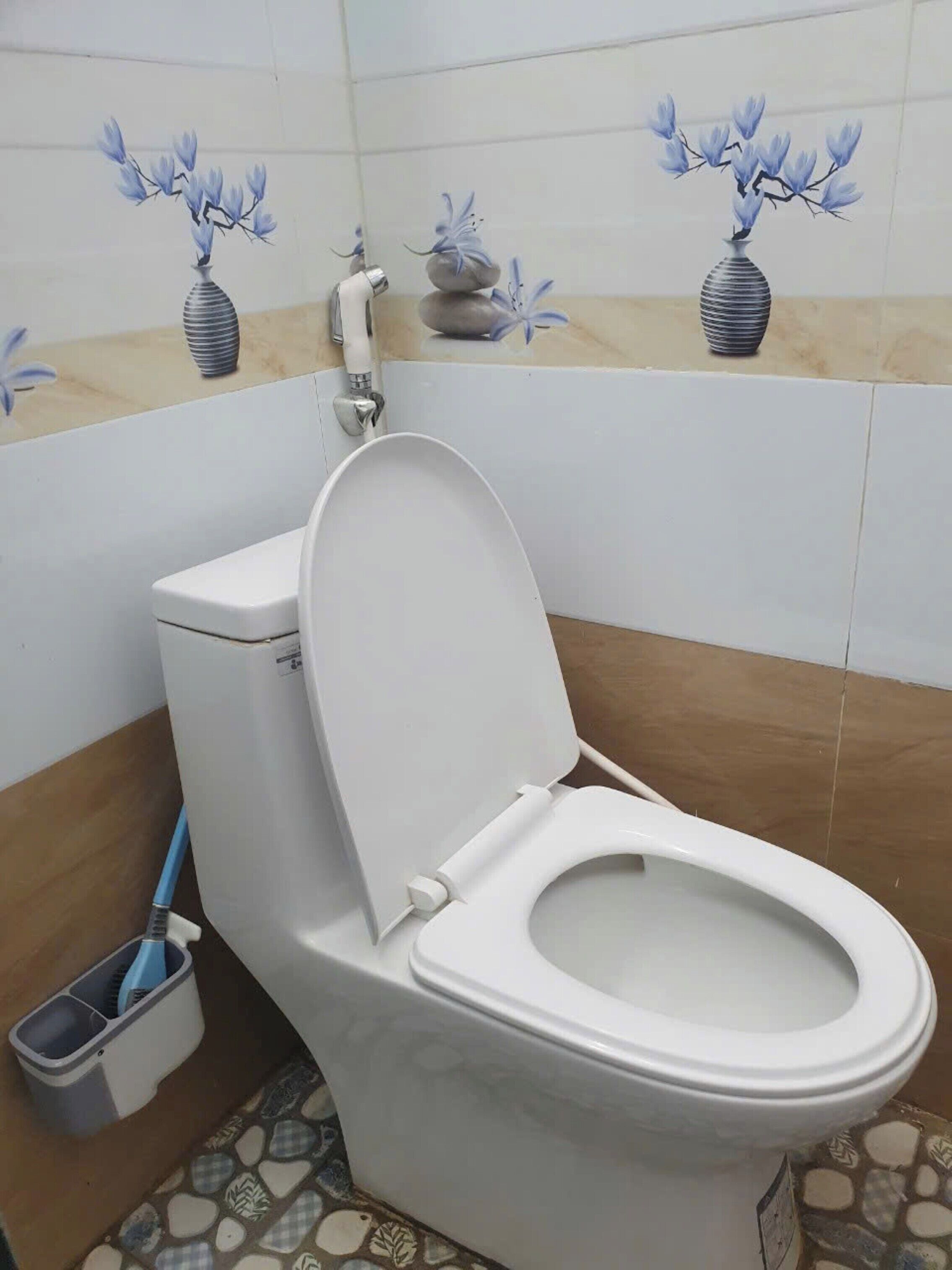 A bathroom with a toilet, a bidet, and a mop bucket.