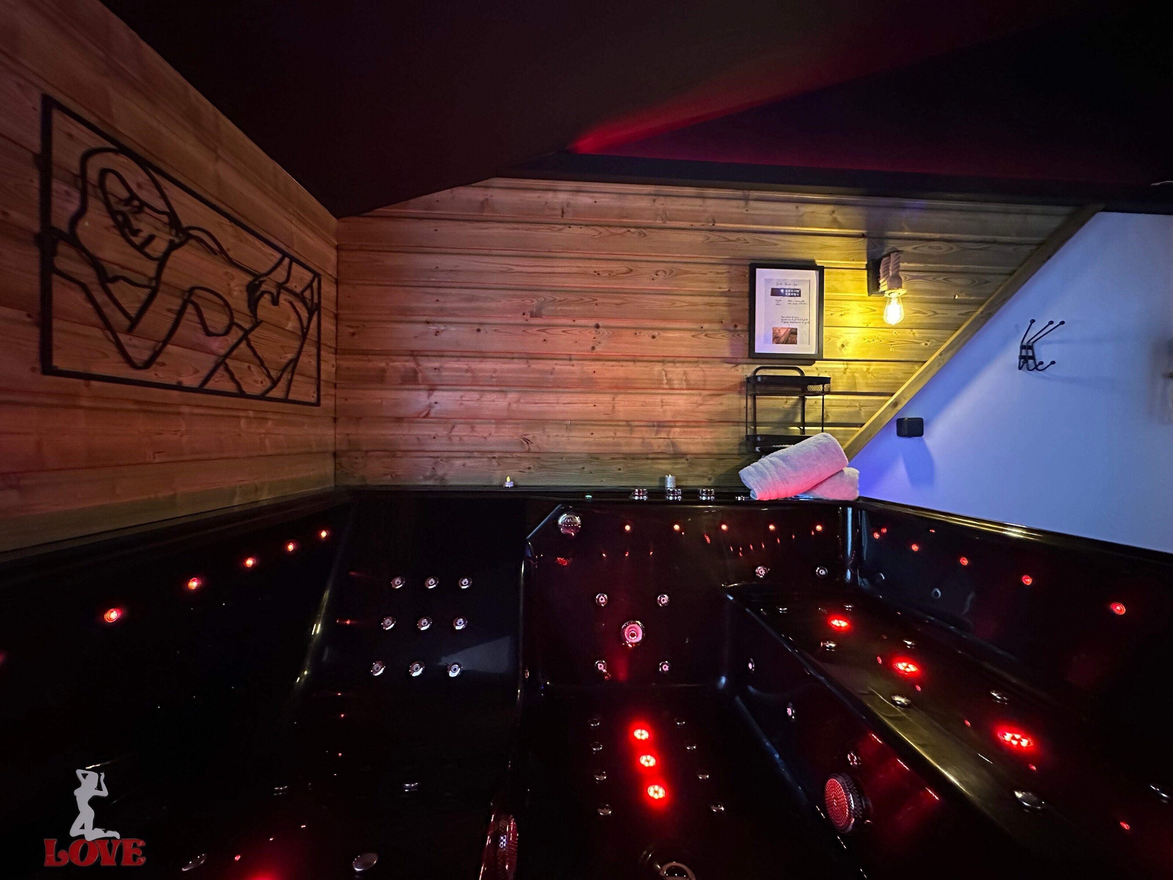 Een kamer met weinig licht, houten wanden, een lijst met een afbeelding en een handdoek op een bankje.