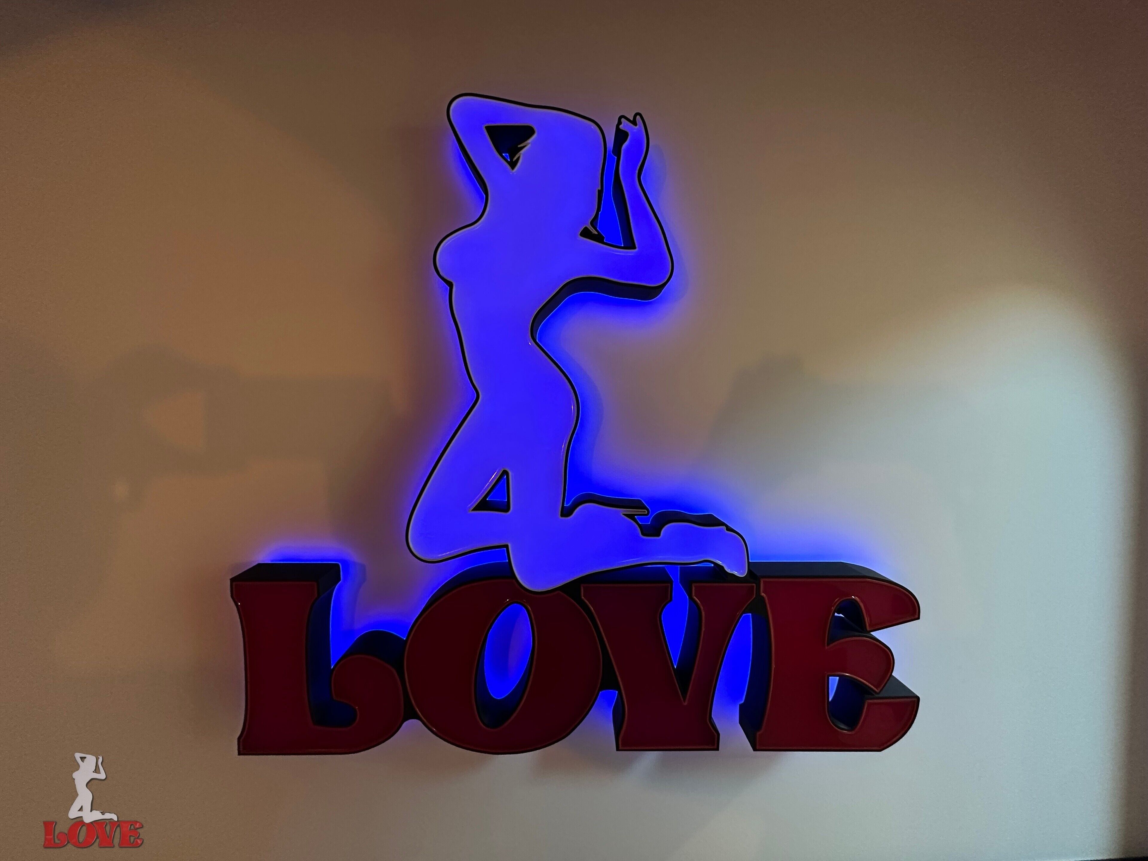 A neon sign with a silhouette of a woman and the word "LOVE" in bold letters.
