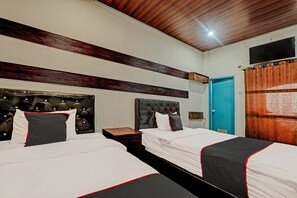 Une chambre d’hôtel avec deux lits, un plafond en bois, un téléviseur à écran plat et une porte bleue.