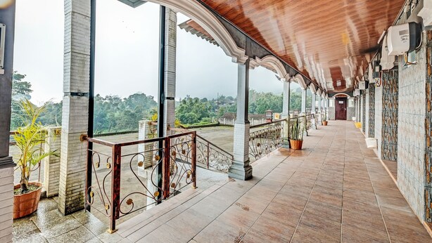 A covered corridor with a wooden ceiling, columns, and potted plants. - Capital O 92276 Hotel Pesona Gunung (Getasan)