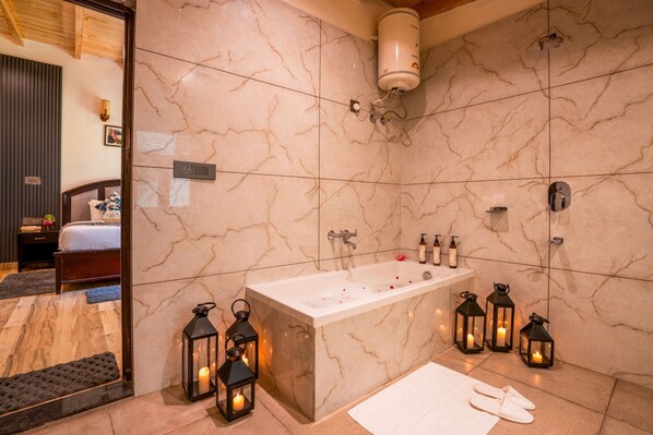 A modern bathroom with a marble wall, a bathtub, and three lit lanterns. - Moustache Select Naukuchiatal By the Lake (Nainital)