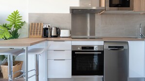 A modern kitchen with stainless steel appliances, including a microwave, oven, and dishwasher. - Castelldefels - Apartment - Sleeps 4 - Beach Side (Castelldefels)