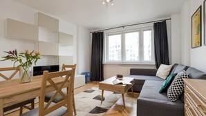 Ein modernes Wohnzimmer mit Sofa, Couchtisch und Essbereich.