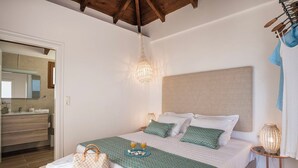A bedroom with a bed, bedside table, and a hanging light fixture. - Luxury 3 bedroom Villa with heated pool (Akrotiri)
