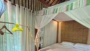 A single bed with a canopy, a hanging chair, and a mosquito net. - Budget Studio with Kitchen – 4 Min to Beach (Malay)