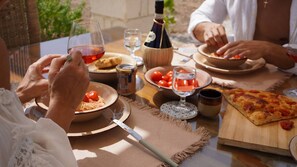 Une table à manger avec de la nourriture, du vin et des verres.