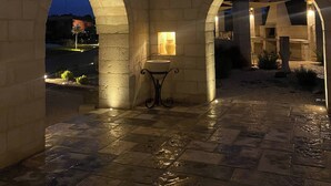 Un patio al aire libre con arcos de piedra y una fuente central.