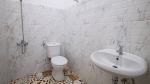 Un baño con inodoro, lavabo y ducha.