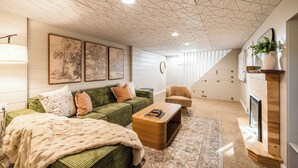 Ein modernes Wohnzimmer mit einem grünen Sofa, einem Holztisch und einem Kamin.