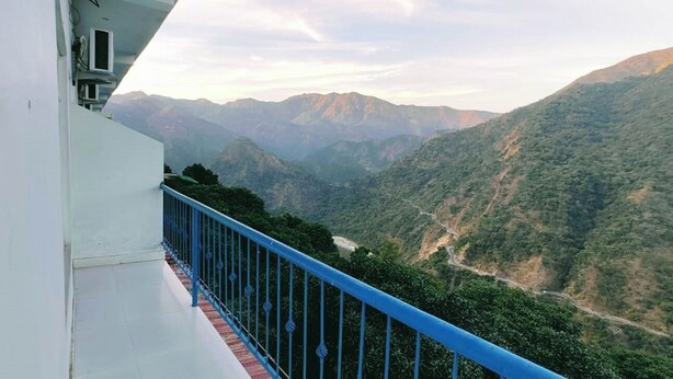 A balcony with a blue railing overlooking a mountainous landscape. - The Yamuna Deck Resort and Cafe (Dhanaulti)