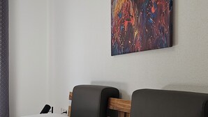 A hotel room with a bed, white pillows, a wooden headboard, and a colorful painting of a bull on the wall. - Elodia Luxury Apartment - Wi-Fi, Smart TV, Terrace, Kitchen, Towels (Heidenheim an der Brenz)