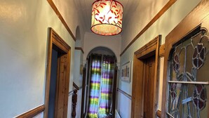 A hallway with wooden doors, a stained glass window, and a decorative light fixture. - House- Parking, Garden & Central Location (Walsall)