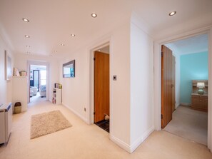 Stylish hallway with a door to another room, bookshelf, and cabinet.