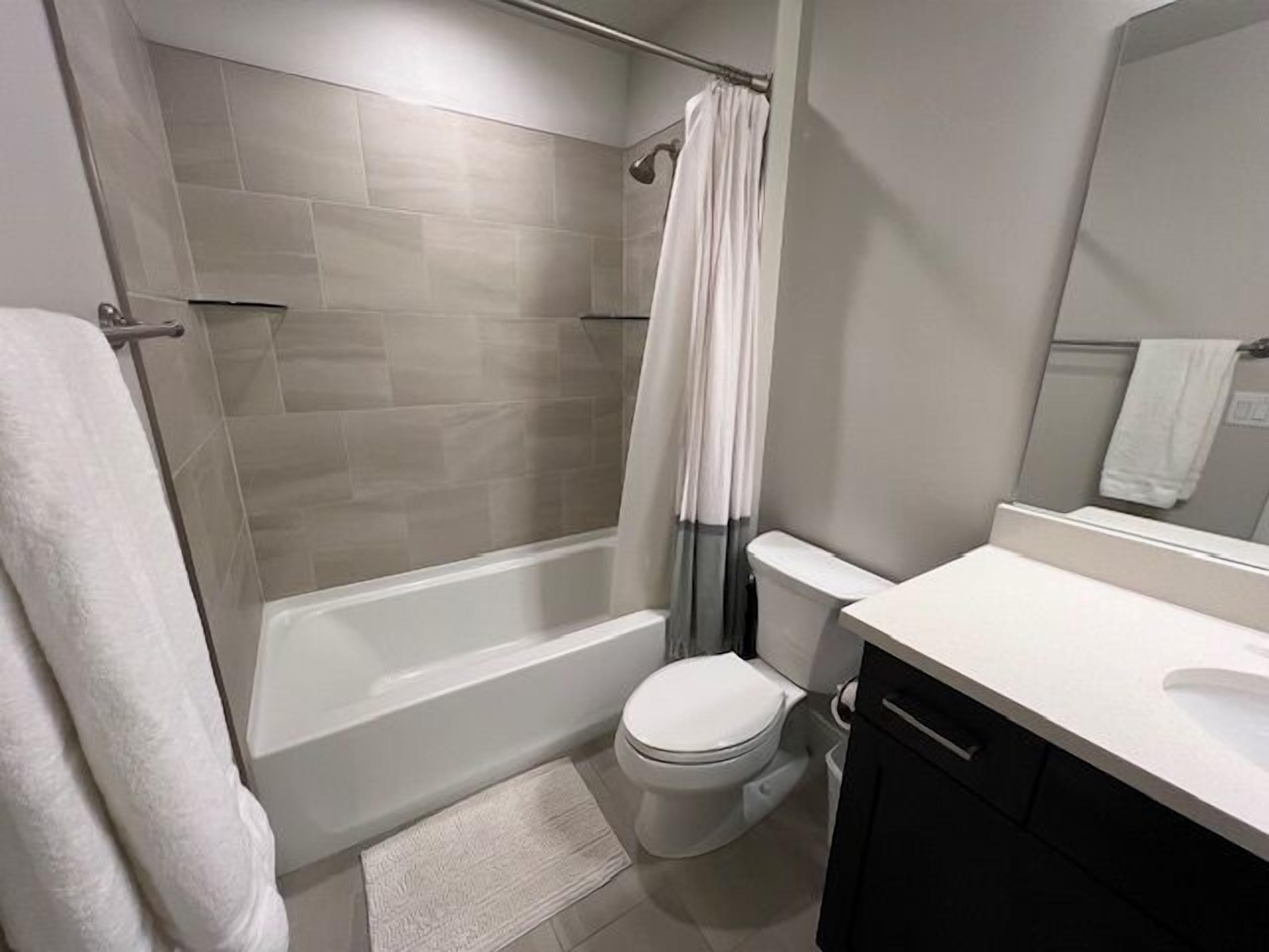 Un baño moderno con ducha, inodoro y lavamanos.