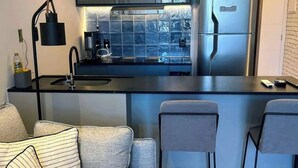 A modern kitchen with a built-in refrigerator, a coffee machine, and a window overlooking a mountainous landscape.