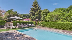 A swimming pool with lounge chairs and umbrellas.