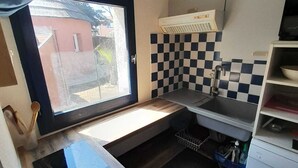 A compact kitchen with a window, a sink, a microwave, and a small refrigerator. - Fisherman's farmhouse between the swimming pool, the Etang de Salses-Leucate and the Mediterranean (Le Barcarès)