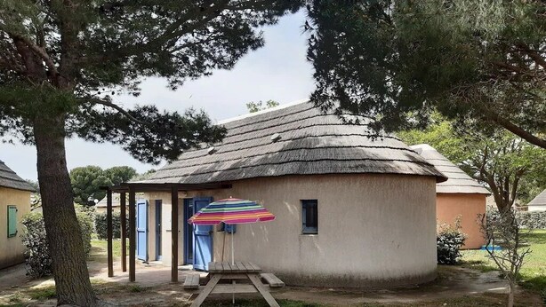 A rustic building with a thatched roof, a small porch, and a colorful umbrella. - Fisherman's farmhouse between the swimming pool, the Etang de Salses-Leucate and the Mediterranean (Le Barcarès)