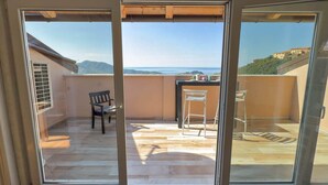 A balcony with a view of the sea, a chair, and a table. - Penthouse Bay View (Sestri Levante)