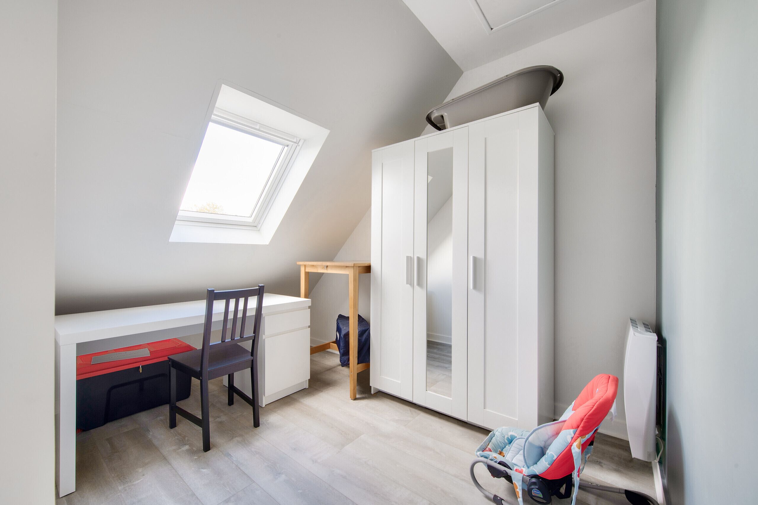 Une pièce comprenant un bureau, une chaise, une armoire et une fenêtre.